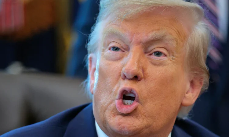 Donald Trump speaking at a rally, referencing artificial intelligence with the phrase “blame AI”