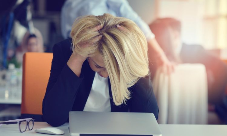 Coworkers reviewing AI-generated workslop on a laptop, highlighting low-quality AI output